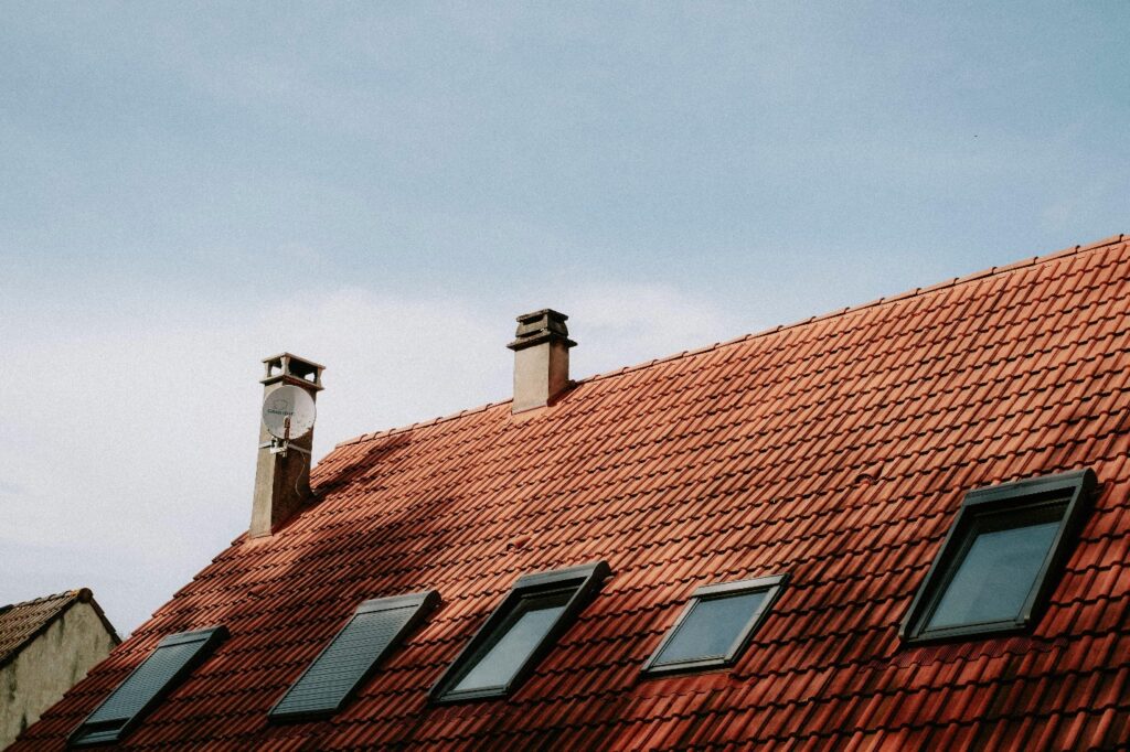 red shingle roof with skylights and chimneys