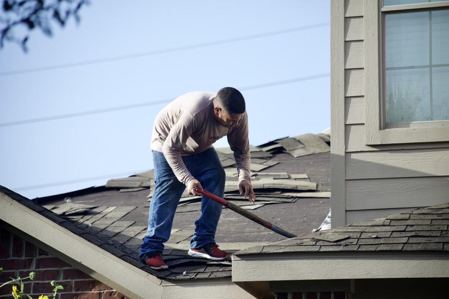 A roofing contractor repairing shingles on a residential roof