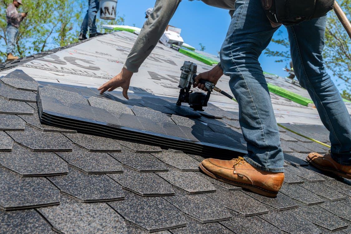 Newly constructed home with modern shingle roofing panels installed on a pitched roof