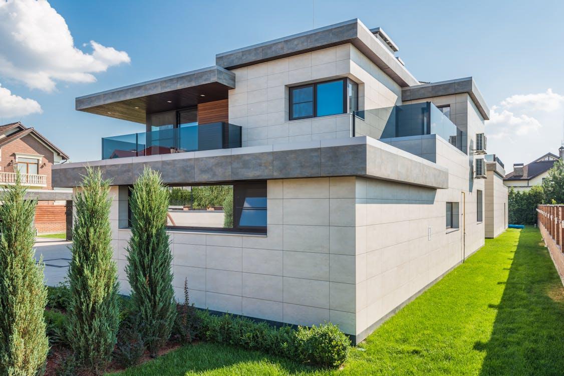 An image of a modern house with green grass around it